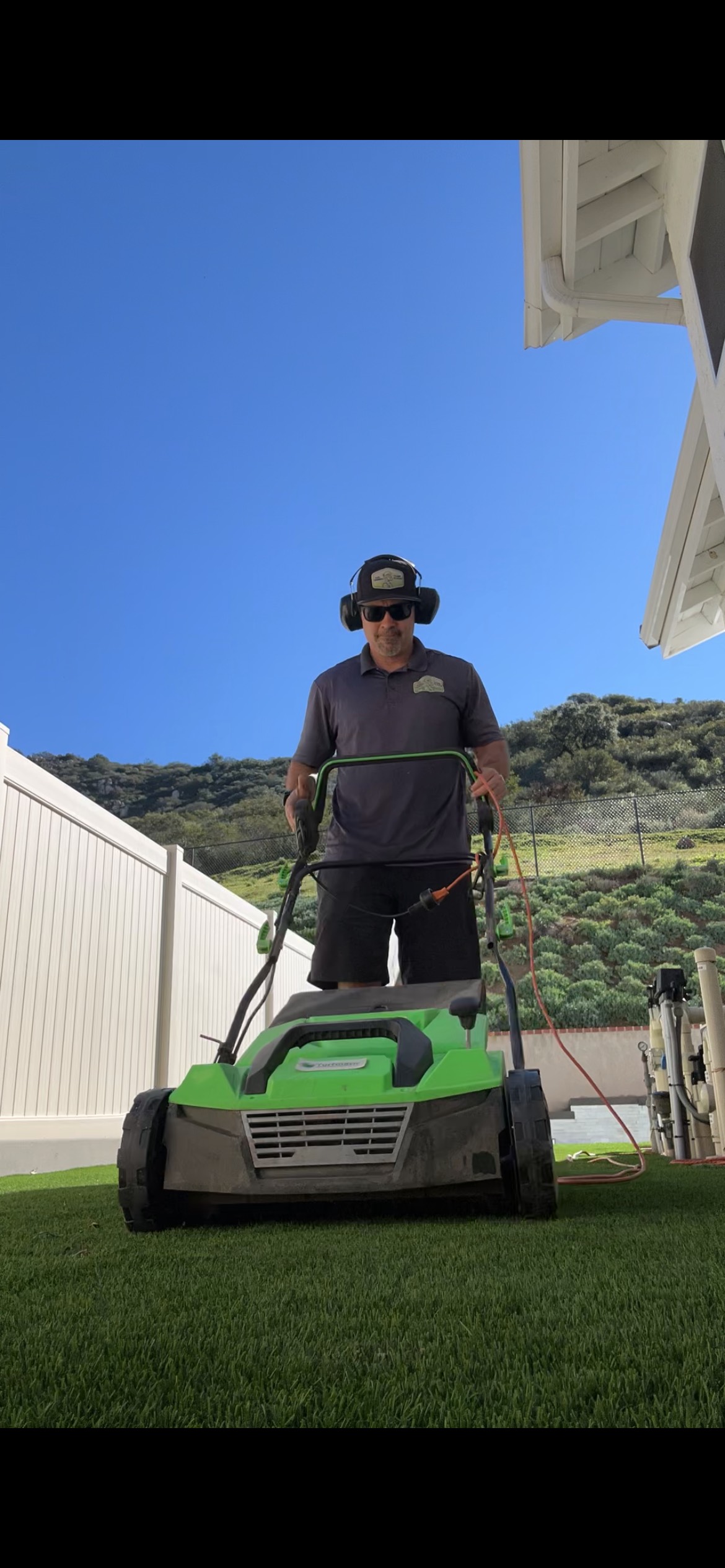 synthetic grass cleaning crew working in San Diego backyard