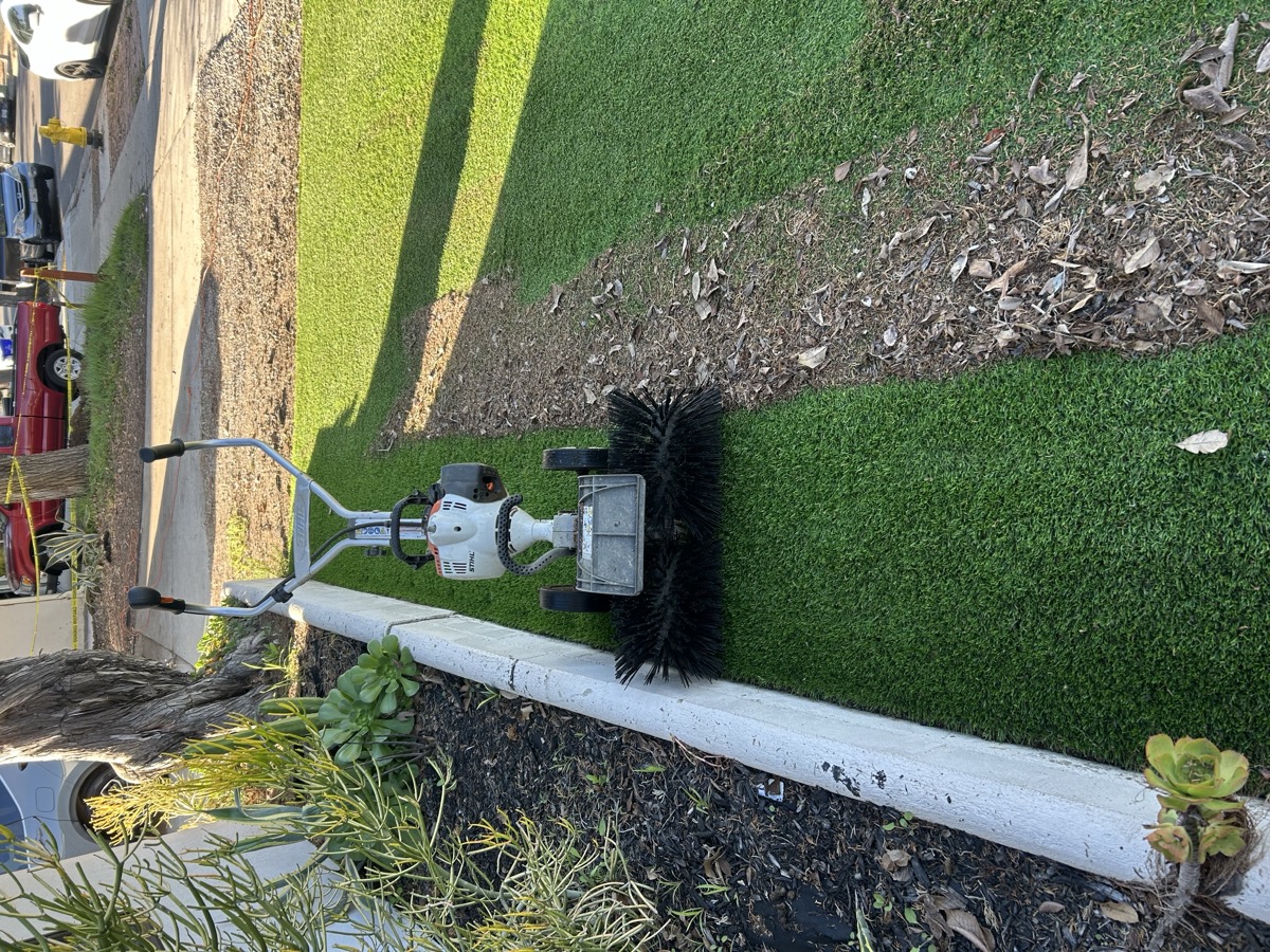 power broom standing artificial grass blades upright after turf cleaning